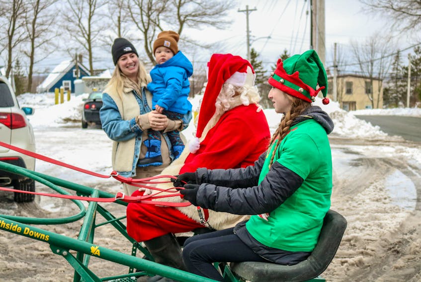 Eddie Brookman as Santa Claus and Colby Lynk as his elf greet Kayla Walsh and her son Woods, during Brookman's final trek as Santa through Whitney Pier on Saturday morning. JESSICA SMITH/CAPE BRETON POST