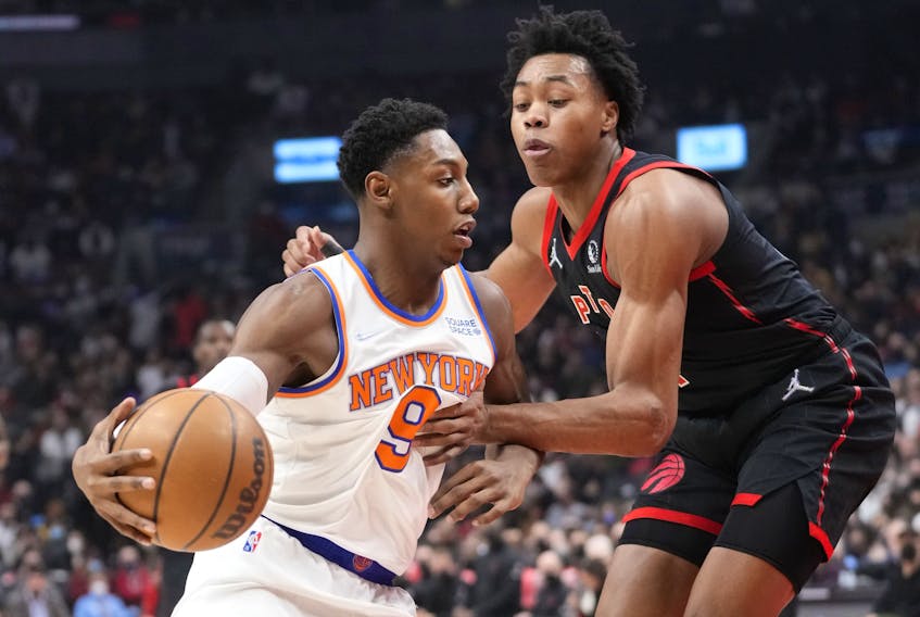 RJ Barrett of the New York Knicks drives  against Scottie Barnes  of the Toronto Raptors during the first half of their basketball game at the Scotiabank Arena on December 10, 2021 in Toronto.