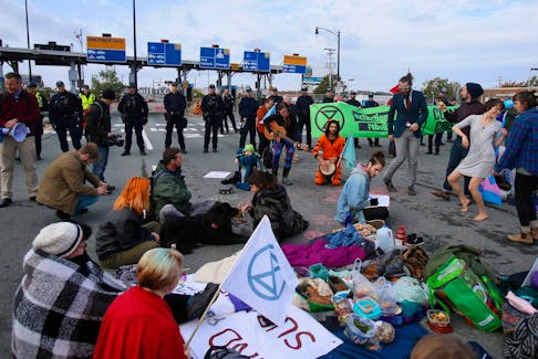 Climate change activists sit in front a phalanx of HRP officers while blocking the Macdonald Bridge during the Extinction Rebellion action Tuesday October 7, 2019. Police took 14 of the group in into custody during the peaceful event. 
- File
TIM KROCHAK/ The Chronicle Herald