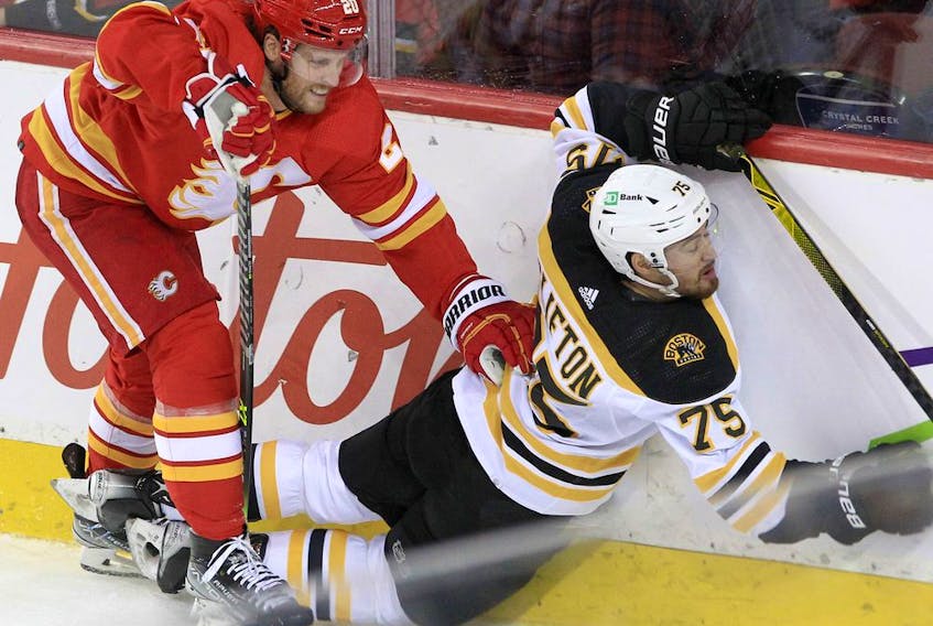  The Calgary Flames’ Blake Coleman takes down the Boston Bruins’ Connor Clifton at Scotiabank Saddledome on Saturday, Dec. 11, 2021.