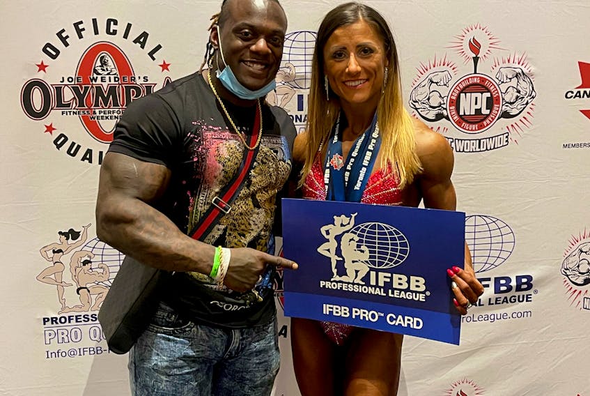 Agata Bridges pictured with trainer Jonni Shreve and her IFBB pro card.