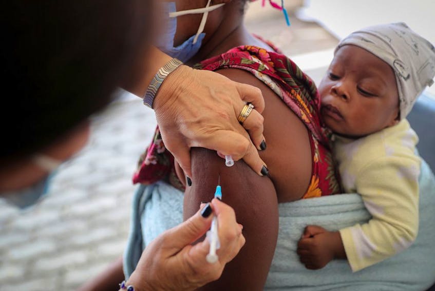 A health care worker administers the COVID-19 vaccine to a young mother in Johannesburg, South Africa, December 04, 2021.  