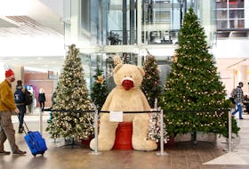 FOR PEDDLE STORY:
Air passengers are seen near a large masked teddy bear, at Halifax Stanfield Airport Tuesday December 14, 2021.

TIM KROCHAK PHOTO