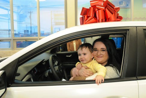 Faith Ann Vokey of St. John’s and her 19-month-old son, Ashton, sit in their new car at the Collision Clinic outlet on Topsail Road in St. John’s Wednesday, Dec. 15. They were named the recipients of the 18th annual Collison Clinic Enriching Lives Car Giveaway program. Each year, automotive technicians with the company donate their time to recondition and repair an accident-damaged vehicle purchased by the company for the Christmas season program. This year, the vehicle is a 2018 Kia Rio. A three-panel external selection committee reviews the many applicants — who must meet various requirements — and narrows them down to three, before a final selection is madw. Vokey works at the Delta Hotel front desk on evening shifts and had to rely on taxis, a bus or her grandfather for transportation, and she will return to school next fall. Joe Gibbons/The Telegram