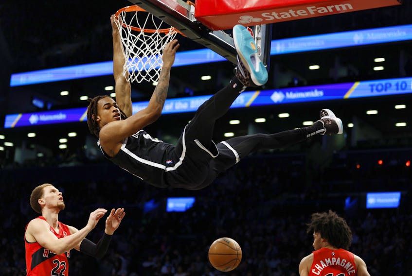 Nic Claxton of the Brooklyn Nets dunks the ball as Malachi Flynn of the Raptors looks on during the first half at Barclays Center on Tuesday, Dec. 14, 2021 in Brooklyn. 