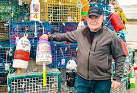 Cape Breton veteran fisherman Brian Adams stands by the lobster pot Christmas tree on Cape Sable Island beside the memorial buoy  he placed on the tree in memory of his son Mitch who was lost at sea in 2007. Contributed