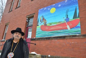 Artist Alan Syliboy with his mural, Little Thunder and the Stone Canoe, which was officially unveiled at the Kings County Museum in Kentville on Dec. 10. KIRK STARRATT