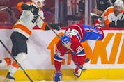 Montreal Canadiens' Jesse Ylonen is tripped by Philadelphia Flyers' Scott Laughton during first period at the Bell Centre on Thursday, Dec. 16, 2021.