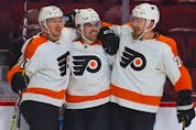Philadelphia Flyers' Jackson Cates, centre, is congratulated by teammates Patrick Brown, left, and Rastus Ristolainen after scoring his first goal of the season during second period at the Bell Centre on Thursday, Dec. 16, 2021.