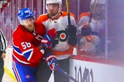 Montreal Canadiens' David Savard shoves Philadelphia Flyers' Rasmus Ristolainen into the boards during second period at the Bell Centre on Thursday, Dec. 16, 2021.
