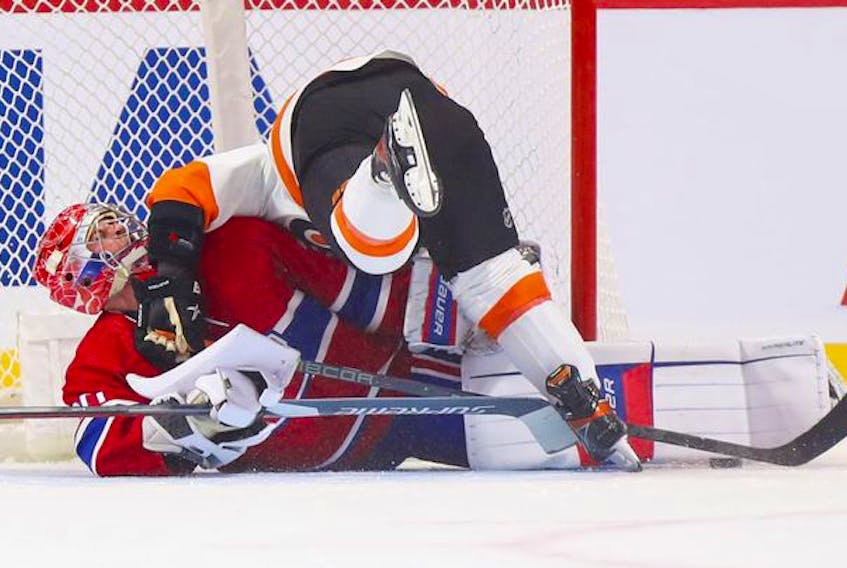 Montreal Canadiens' goalie Cayden Primeau is knocked over by Philadelphia Flyers' Cam Atkinson after making the game-winning save during shootout at the Bell Centre on Thursday, Dec. 16, 2021.