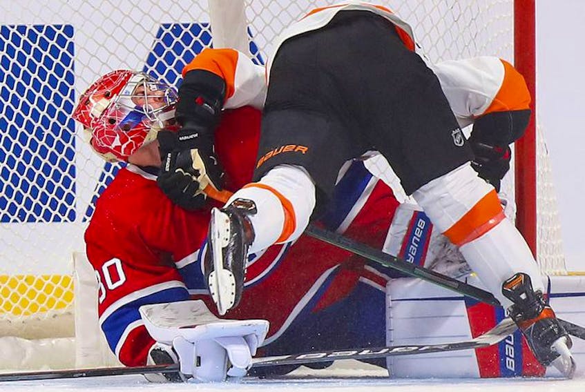 Montreal Canadiens' goalie Cayden Primeau is knocked over by Philadelphia Flyers' Cam Atkinson after making the game-winning save during shootout at the Bell Centre on Thursday, Dec. 16, 2021.