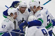 Vancouver Canucks defenceman Quinn Hughes (43), left wing Tanner Pearson (70), defenceman Tyler Myers (57), celebrate with centre J.T. Miller (9), who scored a goal during the third period of an NHL hockey game against San Jose Sharks on Thursday.
