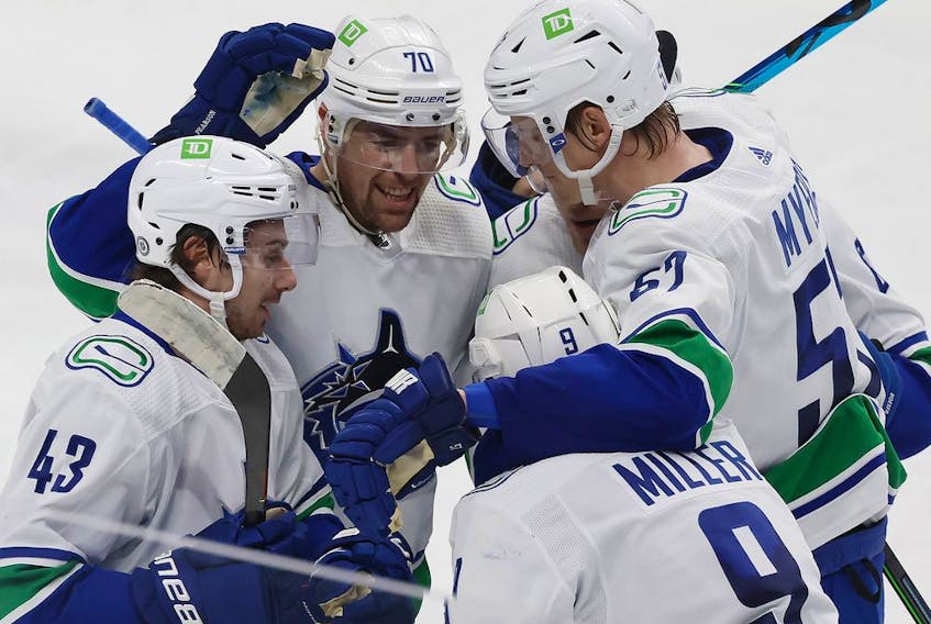 Vancouver Canucks defenceman Quinn Hughes (43), left wing Tanner Pearson (70), defenceman Tyler Myers (57), celebrate with centre J.T. Miller (9), who scored a goal during the third period of an NHL hockey game against San Jose Sharks on Thursday.