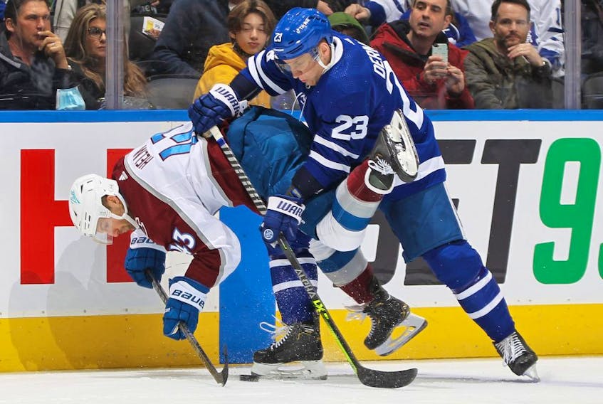  Maple Leafs defenceman Travis Dermott checks the Avs’ Darren Helm on Wednesday. GETTY IMAGES