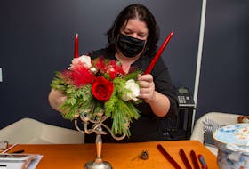Wendy Rashid, owner of Foster's Floral Studio in Eastern Passage works on a Christmas candelabra at her new shop on Thursday, Dec. 16, 2021.