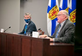 Premier Tim Houston, left, looks on as Dr. Robert Strang speaks at the COVID-19 news update in Halifax on Dec. 17, 2021.