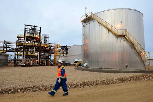 An oilfield worker walks past the Statoil oil sands facility near Conklin, Alberta.