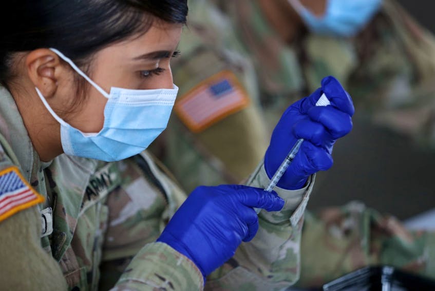 A U.S. Army soldier from the 2nd Armored Brigade Combat Team, 1st Infantry Division, prepares Pfizer COVID-19 vaccines to inoculate people at the Miami Dade College North Campus on March 09, 2021 in North Miami, Florida. (Photo by Joe Raedle/Getty Images)