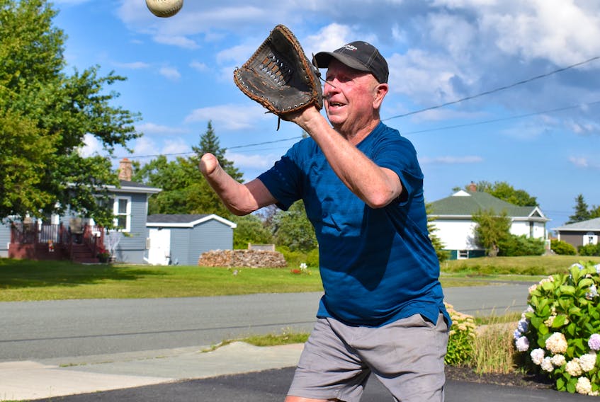 Teddy Morrison of Glace Bay prepares to catch a ball in his glove while playing catch on his front lawn in late August. Morrison has lived the majority of his life with one hand, but that never stopped him from playing sports. JEREMY FRASER/CAPE BRETON POST
