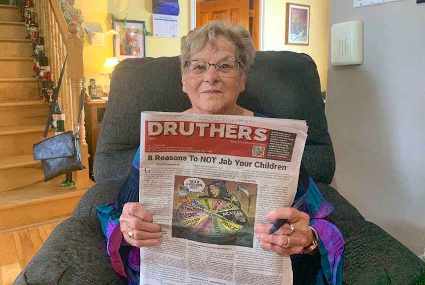 Ruth MacNeil holds the copy of “Druthers” that ended up in her newspaper box recently. "I was really disturbed,” said the 87-year-old Big Pond resident. “I went out to get my paper and then when when I got this .... well as soon as I started reading it, I knew what it was all about — it was just anti-vaccination, and that’s basically it.” Chris Connors/Cape Breton Post