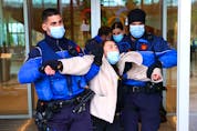 Police remove members of the Tibetan Youth Association in Europe and Students for a Free Tibet during a protest against the Beijing 2022 Olympic Games outside the International Olympic Committee in Lausanne, Switzerland on Dec. 11, 2021. REUTERS file photo/Denis Balibouse