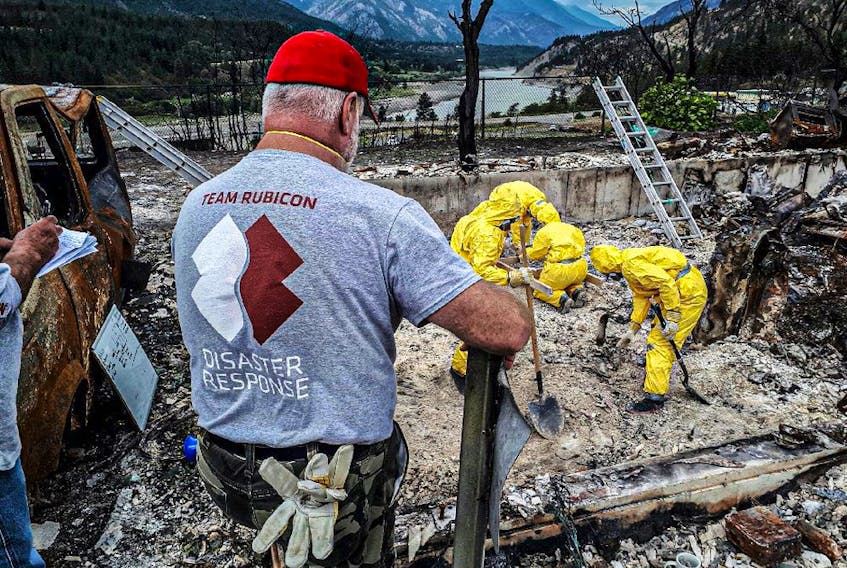 A Team Rubicon 'Greyshirt' leads a recovery effort in support of Lytton First Nation resident.