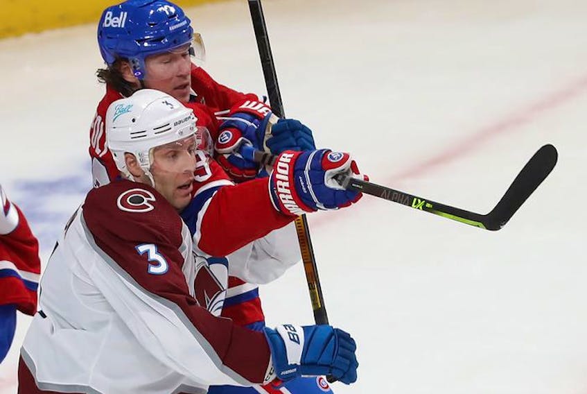 Montreal Canadiens' Tyler Toffoli (73) holds back Colorado Avalanche's Jack Johnson (3) by bringing up his stick during first period action in Montreal on Thursday, Dec. 2, 2021.