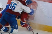 Montreal Canadiens' Josh Anderson (17) is slammed hard into the boards by Colorado Avalanche's Kurtis MacDermid (56) during second period in Montreal on Thursday, Dec. 2, 2021. 