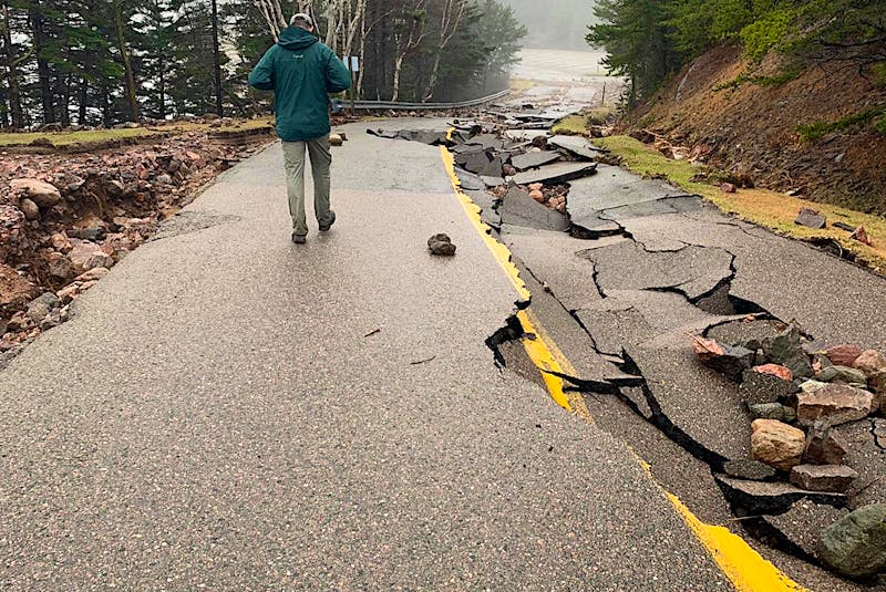 A Parks Canada employee walks down a road in Ingonish, along the side that flooding didn't cause the pavement to crack and crumble up. CONTRIBUTED/PARKS CANADA 