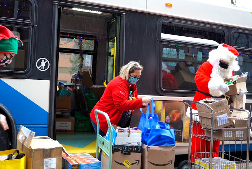 Dec. 3, 2021 - Santa and his helpers load donations for Feed Nova Scotia onto a Halifax Transit bus on Friday as part of the Stuff-A-Bus campaign. Eight buses collected donations from 97 different locations around HRM on Friday as part of the effort to help those in need this Christmas. - Jacob Surette