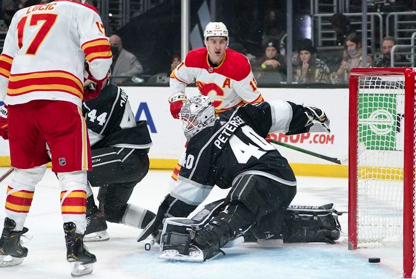Los Angeles Kings goaltender Cal Petersen is scored on by Calgary Flames defecseman Noah Hanifin, not seen, as left winger Milan Lucic, left, and centre Mikael Backlund watch at Staples Center in Los Angeles on Thursday, Dec. 2, 2021. 
