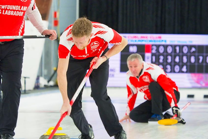 Mark Noseworthy (background) watches as lead Steve Routledge starts sweeping a shot from the skip at the Everest Canadian curling club championship in Ottawa.
