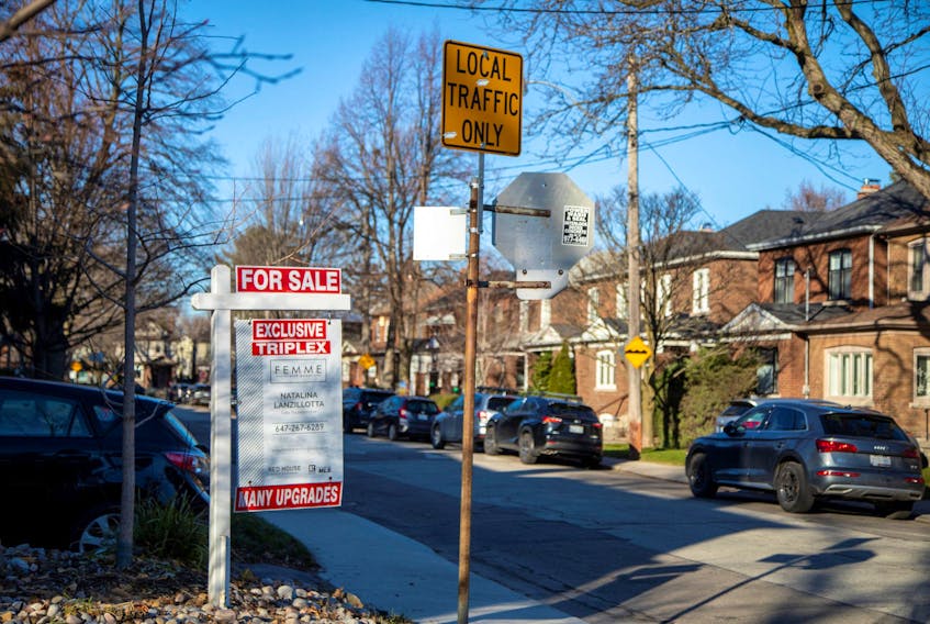 A for sale sign is displayed outside a home in Toronto, Ontario in Toronto, Ontario, Canada December 13, 2021. 