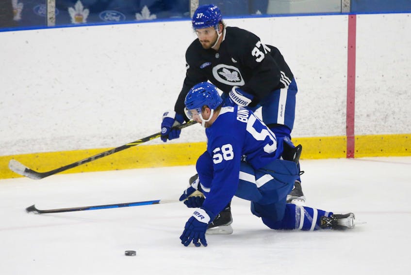 Maple Leafs’ Timothy Liljegren (above) tries to get around Michael Bunting during practice earlier this week. Liljegren was placed on the COVID protocol list yesterday. 