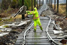A member of a cleanup crew in Abbotsford, B.C., removes storm debris from a rail line in December. REUTERS/Jennifer Gauthier
