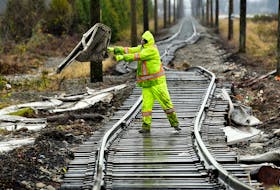 A member of a cleanup crew in Abbotsford, B.C., removes storm debris from a rail line in December. REUTERS/Jennifer Gauthier
