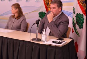 P.E.I. Agriculture Minister Bloyce Thompson, right, and Carolyn Sandford, director of animal and plant health, regulatory, and analytical laboratories, listen to comments during a Nov. 22 media briefing about the closure of the U.S. border to fresh P.E.I. potatoes.