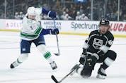  Vancouver Canucks’ Luke Schenn, left, shoots under defence by Los Angeles Kings’ Brendan Lemieux during first period of an NHL hockey game Thursday, Dec. 30, 2021, in Los Angeles.