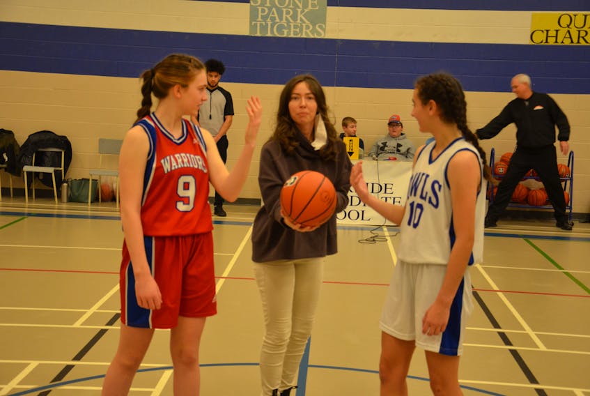 The 44th annual Glenn Edison Memorial Summerside Intermediate School (SIS) tip-off basketball tournament took place recently. The event honours the memory of Edison, a former principal and coach at SIS who died in 2014 after a brief battle with cancer.  Edison's daughter, Gale, prepares to perform the ceremonial tip-off between the SIS Owls' Quinn Gavin, right, and East Wiltshire's Sophie LeClair.