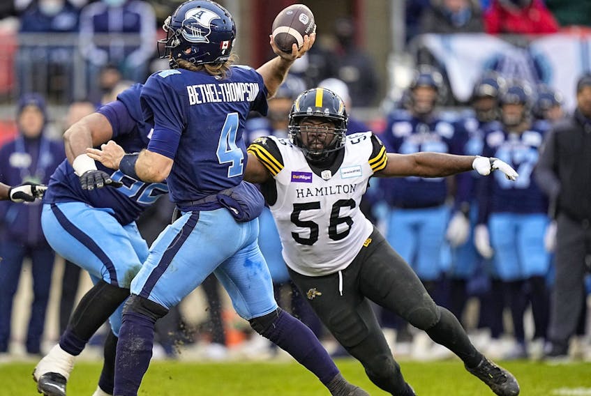 Tiger-Cats defensive end Ja’Gared Davis (right) pressure Argonauts quarterback McLeod Bethel-Thompson during the Eastern Division final yesterday. 
