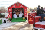 While the 41st Annual Souris Christmas Parade was held in reverse this year to meet pandemic protocols, some guests, like those on the right, took a horse-and-wagon to the event rather than a car. 