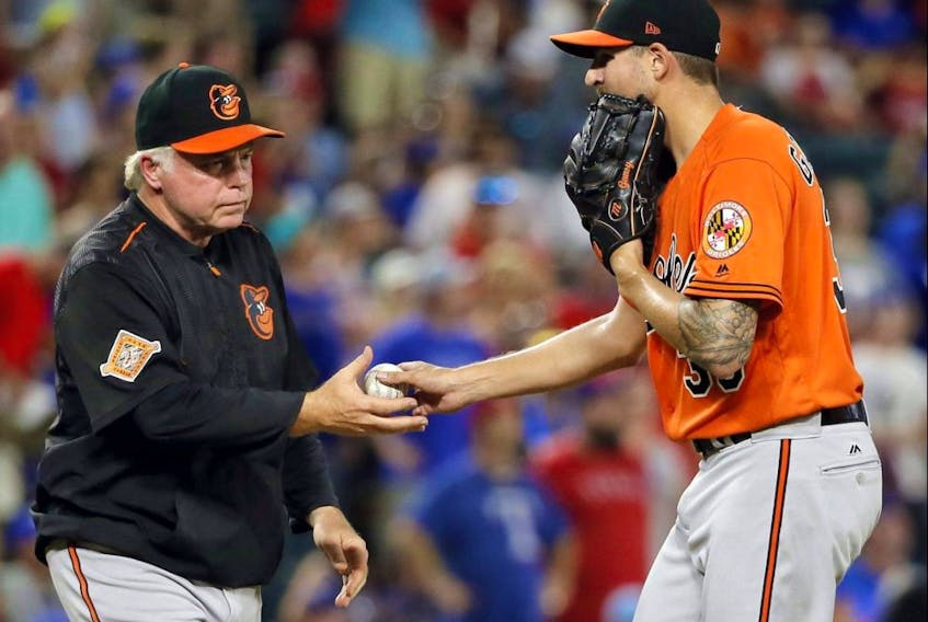 Baltimore Orioles manager Buck Showalter (left) takes the ball from starting pitcher Kevin Gausman, in the ninth inning of a baseball game against the Texas Rangers on July 29, 2017, in Arlington, Texas. 

