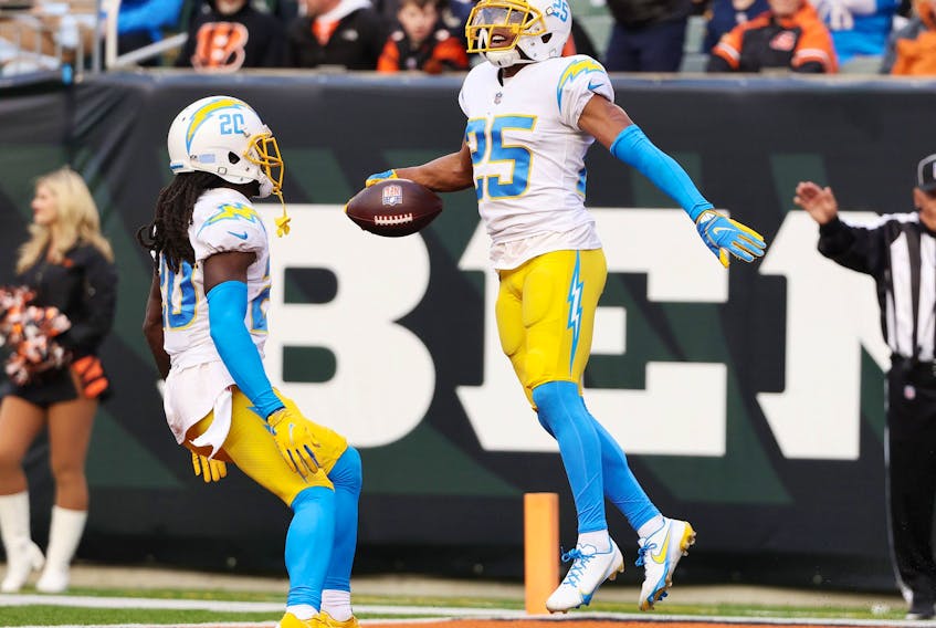 Chargers’ Chris Harris celebrates his interception with teammate Tevaughn Campbell against the Bengals in Cincinnati.  
