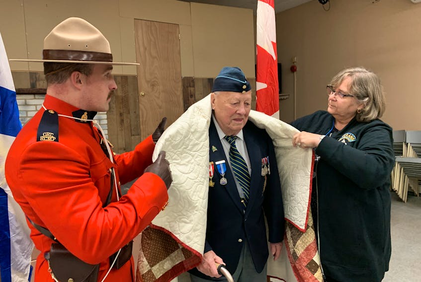 Second World War veteran David Coleman is presented his Quilt of Valour by society representative Rhoda Moore during a ceremony in Oxford on Sunday. Looking on is Oxford RCMP member Const. Paul Cheesman. Darrell Cole – SaltWire Network