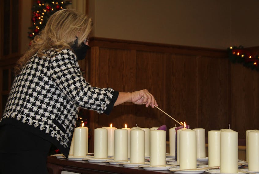 At Summerside's National Day of Remembrance and Action on Violence Against Women service on Monday, Dec. 6, a woman lights a candle in memory of the victims of the 1989 École Polytechnique shooting.