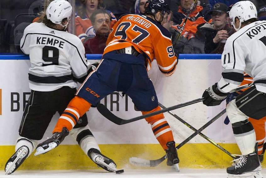 Edmonton Oilers centre Connor McDavid (97) checks the Los Angeles Kings' Adrian Kempe (9) during third period NHL action at Rogers Place, in Edmonton Sunday Dec. 5, 2021. McDavid got a game misconduct penalty on the play. 
