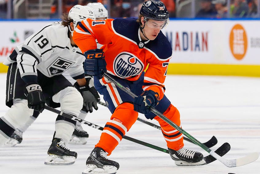 Edmonton Oilers forward Ryan McLeod (71) carries the puck while Los Angeles Kings forward Alex Iafallo (19) tires to knock it away from him during the first period at Rogers Place on Dec. 5, 2021. 