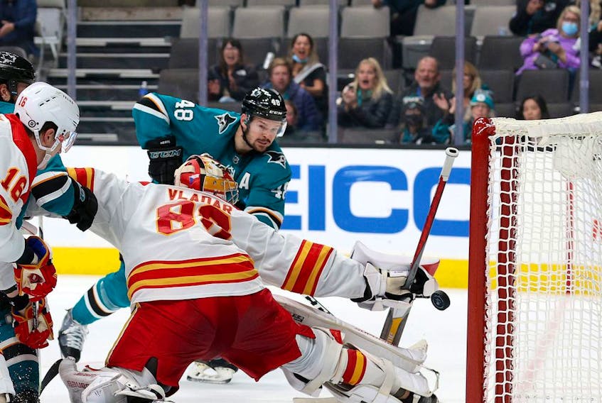 Sharks forward Tomas Hertl scores his second of three goals on the night as Flames goalie Dan Vladar reaches for the puck at SAP Center in San Jose on Tuesday night. The Sharks won 5-3.