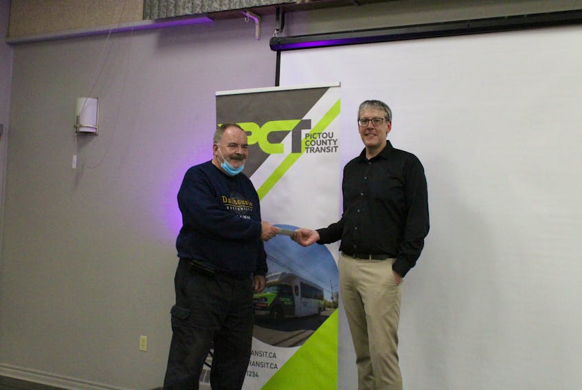 Faus Johnson (left) receiving an award of recognition from CHAD Transit executive director Danny MacGillivray (right).